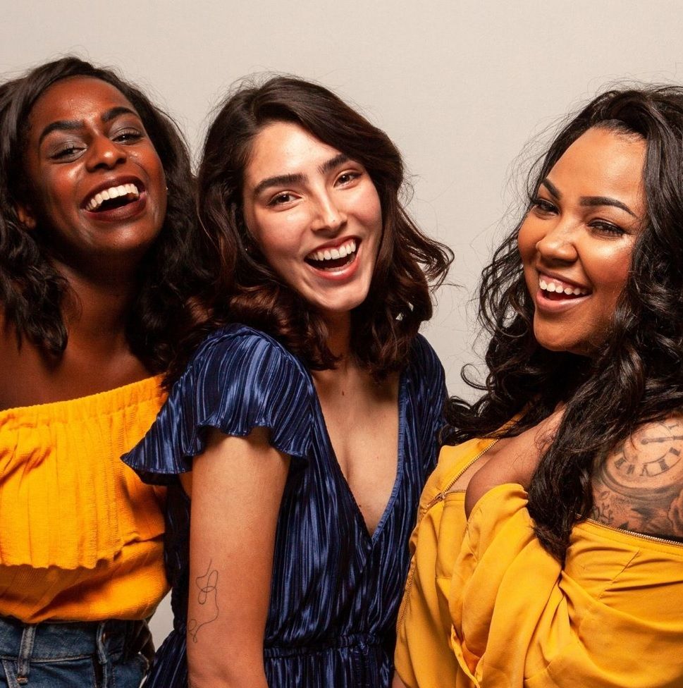 Three women posing for a picture in yellow and blue.